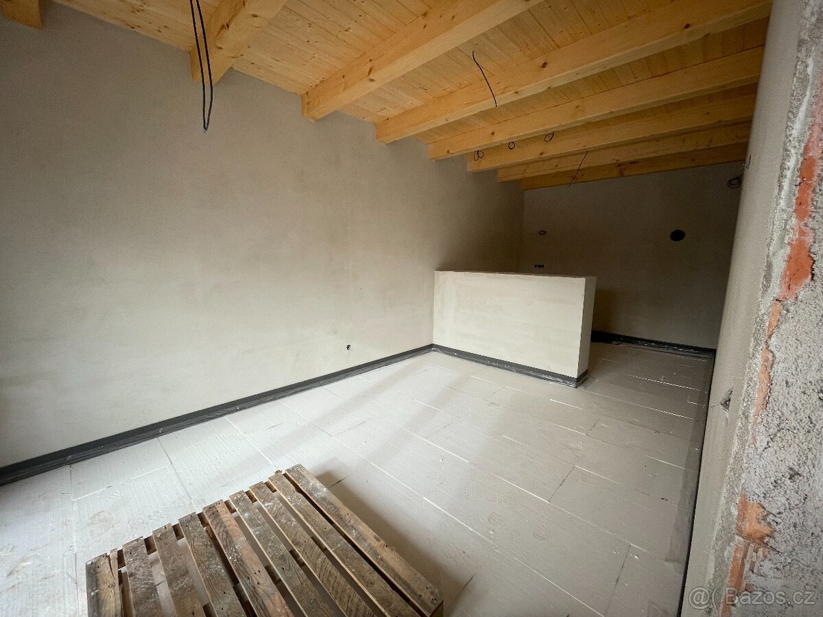 Podkrovní prostor s hotovými omítkami a dřevěným krovem
